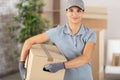 female courier with carboard box in residential room Royalty Free Stock Photo