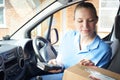 Female Courier In Van Delivering Package To Domestic House Royalty Free Stock Photo
