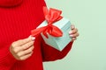 Female in cozy sweater open gift box. Woman hold christmas present, isolated. Seasonal winter sales Royalty Free Stock Photo