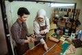 female craftsman in hijab with male craftsman looking a pad Royalty Free Stock Photo