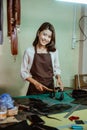 female craftswoman smiles while smoothing of the tanned leather