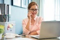 Female creative designer talking on cell phone at her workplace.