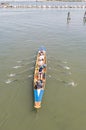 Female crew is training on a rowing boat in venice canal.