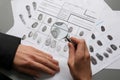 Female criminalist exploring fingerprints with magnifier, closeup Royalty Free Stock Photo