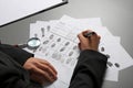 Female criminalist filling fingerprints card at table