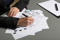 Female criminalist filling fingerprints card at table