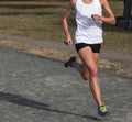 Female Cross Country runner racing on a gravel path