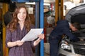 Female Customer In Auto Repair Shop Satisfied With Bill For Car Royalty Free Stock Photo