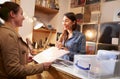 Female customer being served at the counter of a record shop