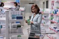 Female customer examining vitamins box on shelves Royalty Free Stock Photo