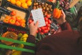 Female customer follows shopping list. buying fruits and vegetables in market. Royalty Free Stock Photo