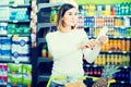 Female customer looking at notes in shopping list Royalty Free Stock Photo