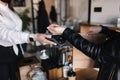 Female customer making wireless or contactless payment using smartwatch. Closeup of hands during payment. Store worker