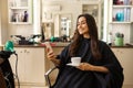 Female customer with phone and coffee, hairsalon Royalty Free Stock Photo