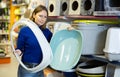 Confident woman choosing plastic litterbox for cats in pet shop Royalty Free Stock Photo