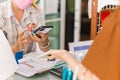 Female customer in protective mask make contactless mobile payment sales woman in retail shop.