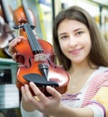 Female customer purchasing violins in store Royalty Free Stock Photo