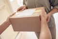 Female customer receiving courier service delivery parcel box at home, close up.