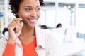 Female customer service executive standing with headset standing in office