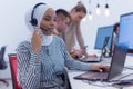 Female Customer Service Representative Answer Client`s Questions in a Headset. Multi-Ethnic Team of Specialists. Happy african