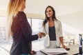 Female customer shaking hands with real estate agent agreeing to sign a contract standing in new modern studio apartment Royalty Free Stock Photo