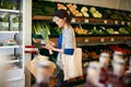 Female Customer With Shopping Basket Buying Fresh Leeks In Organic Farm Shop