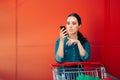 Worried Woman Checking Shopping List on Her Smartphone Royalty Free Stock Photo