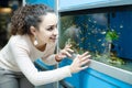 Female customer watching fish in aquarium tank Royalty Free Stock Photo