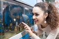 Female customer watching fish in aquarium tank Royalty Free Stock Photo