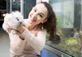 Female customer watching fluffy chinchilla in petshop