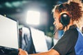 Female cybersport gamer. Side view of a young fully concentrated mixed race girl wearing headphones playing online video