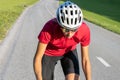 Female cycling rider in maximal effort during an uphill race