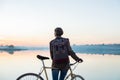 Female cyclist enjoying beautiful blue hour scene by the lake. W