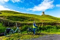 Female cyclist having a break with the Doonagore Castle tower in the background