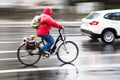 Female cyclist in rainy city traffic