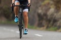 Female cyclist riding racing bicycle, woman cycling on countryside summer road