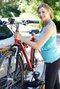 Mature Female Cyclist Taking Mountain Bike From Rack On Car Royalty Free Stock Photo