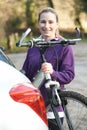 Female Cyclist Taking Mountain Bike From Rack On Car Royalty Free Stock Photo