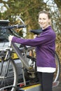 Female Cyclist Taking Mountain Bike From Rack On Car Royalty Free Stock Photo