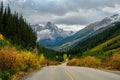 Female cyclist training on a mountain road that looks idyllic in beautiful fall colors with the Cathedral Mountain in the