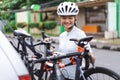 female cyclist unloading her road bicycle on a rack in the back of her car Royalty Free Stock Photo