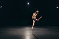 Female dancer jumps on empty stage Royalty Free Stock Photo