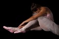 Female dancer sit on floor looking sad in pink tutu low key