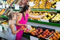 Female with daughter selecting apples in fruit section Royalty Free Stock Photo