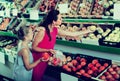 Female with daughter selecting apples in fruit section Royalty Free Stock Photo