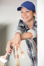 female decorator holding various paintbrushes