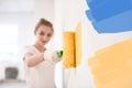 Female decorator painting wall with roller indoors Royalty Free Stock Photo