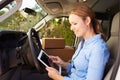 Female Delivery Driver Sitting In Van Using Digital Tablet Royalty Free Stock Photo