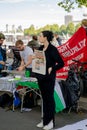 Female demonstrator holding a newspaper in front of a stand at the Chris Kaba demonstration