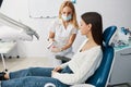 Woman dentist moving toothbrush on upper row of teeth mockup